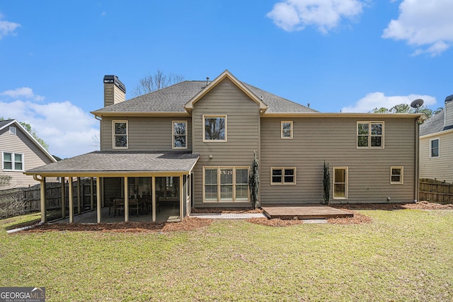 rear view of property featuring a patio, a chimney, fence, and a yard