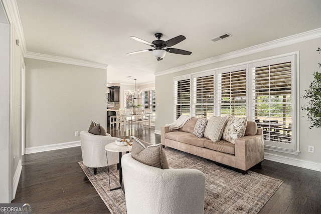 living area with visible vents, ornamental molding, dark wood-type flooring, baseboards, and ceiling fan with notable chandelier