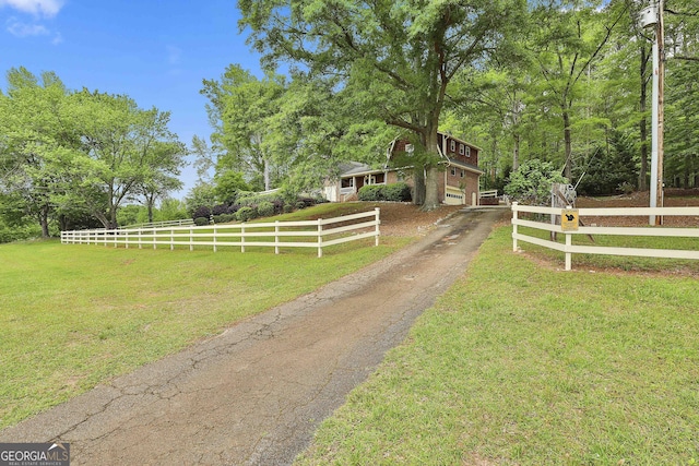 exterior space featuring fence, a yard, and driveway