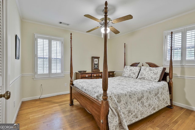 bedroom featuring crown molding, baseboards, visible vents, and light wood-style flooring
