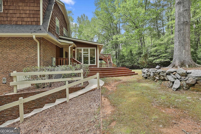 view of yard featuring a wooden deck, stairs, and a sunroom
