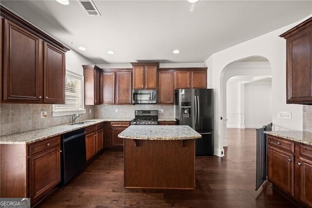 4735 Belcrest Way, Cumming, GA 30040 - kitchen featuring dark wood finished floors, arched walkways, black appliances, a center island, and backsplash