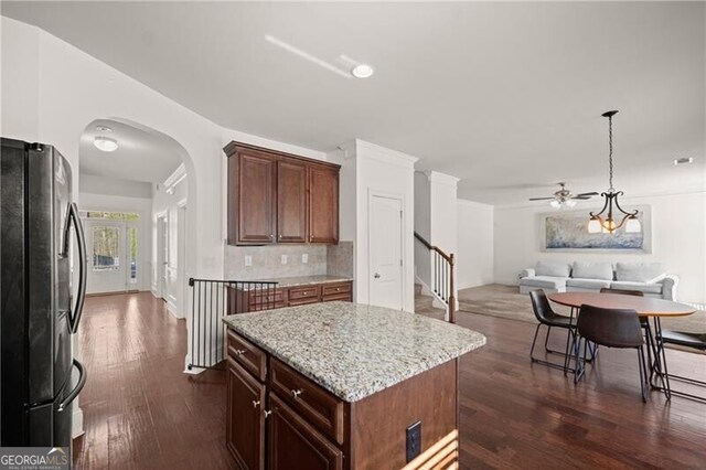 4735 Belcrest Way, Cumming, GA 30040 - kitchen with arched walkways, dark wood-style flooring, ceiling fan, freestanding refrigerator, and backsplash