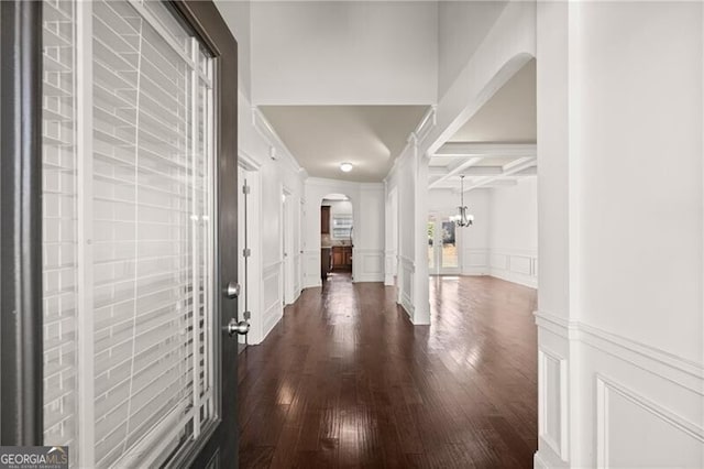 4735 Belcrest Way, Cumming, GA 30040 - corridor with dark wood-style flooring, beamed ceiling, a decorative wall, coffered ceiling, and arched walkways