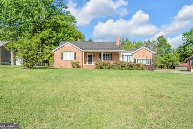 ranch-style home with brick siding, a front lawn, and a chimney
