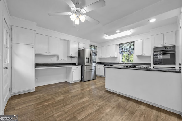 kitchen featuring stainless steel fridge, dark wood-style flooring, dark countertops, and black oven