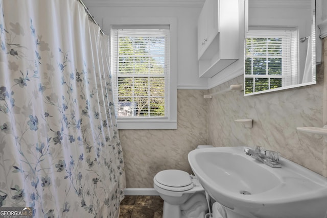 bathroom with baseboards, a shower with curtain, a sink, and toilet