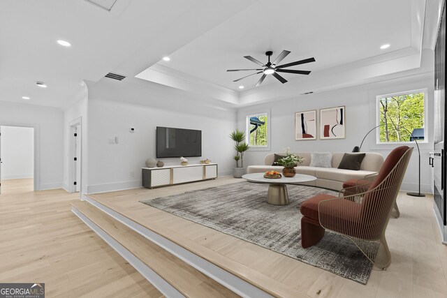 living area featuring light wood-type flooring, recessed lighting, a ceiling fan, visible vents, and a raised ceiling