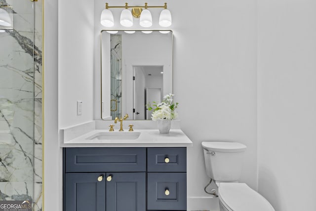 full bathroom featuring toilet, vanity, and a marble finish shower
