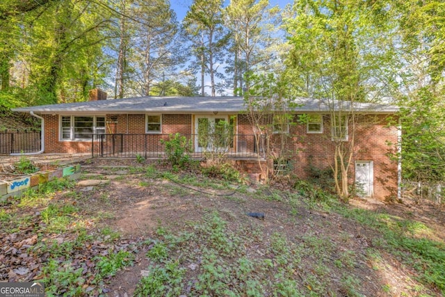 ranch-style house featuring brick siding and a chimney