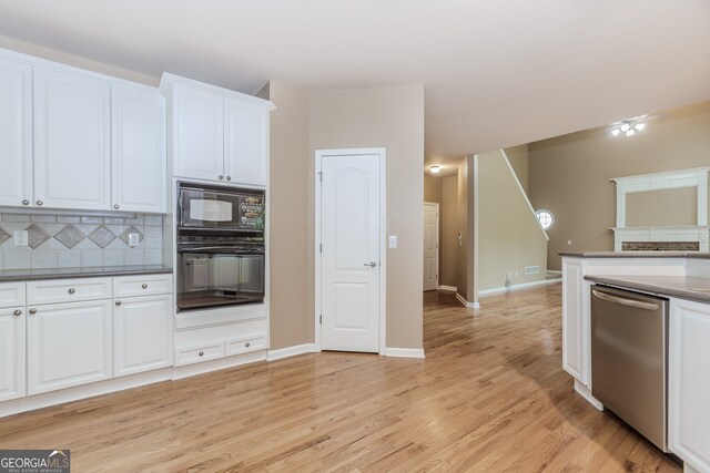 4106 Creekview Ridge Dr NE, Buford, GA 30518 - unfurnished dining area with a tray ceiling, light wood-type flooring, a wainscoted wall, and an inviting chandelier