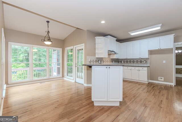 4106 Creekview Ridge Dr NE, Buford, GA 30518 - kitchen with stainless steel appliances, a peninsula, light wood-type flooring, backsplash, and under cabinet range hood