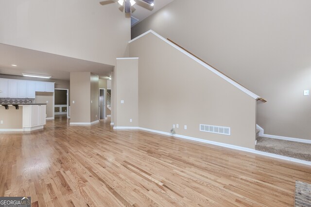 4106 Creekview Ridge Dr NE, Buford, GA 30518 - unfurnished living room featuring visible vents, high vaulted ceiling, wood finished floors, ceiling fan, and a fireplace