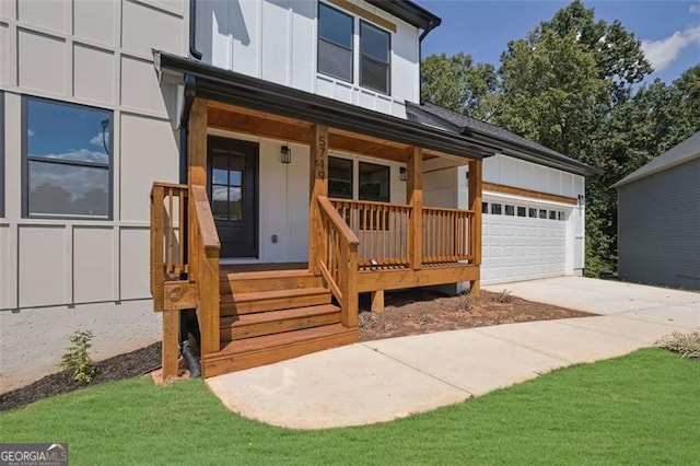 5719 Calm Valley Pt, Flowery Branch, GA 30542 - view of front of home with a porch, board and batten siding, concrete driveway, and a garage