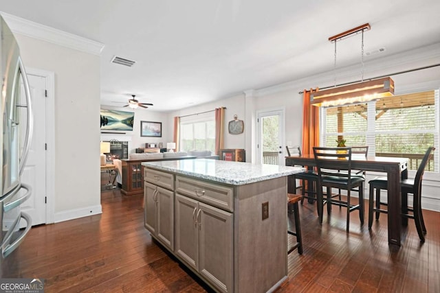 kitchen with gray cabinets, a center island, freestanding refrigerator, dark wood-type flooring, and ceiling fan