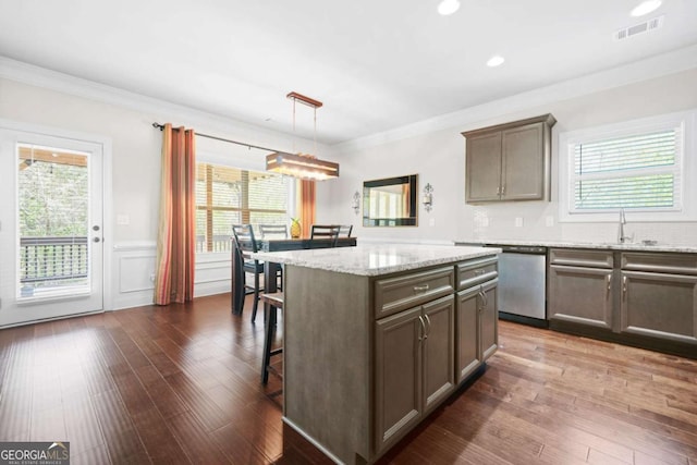 kitchen featuring dark wood-style floors, a center island, crown molding, visible vents, and dishwasher