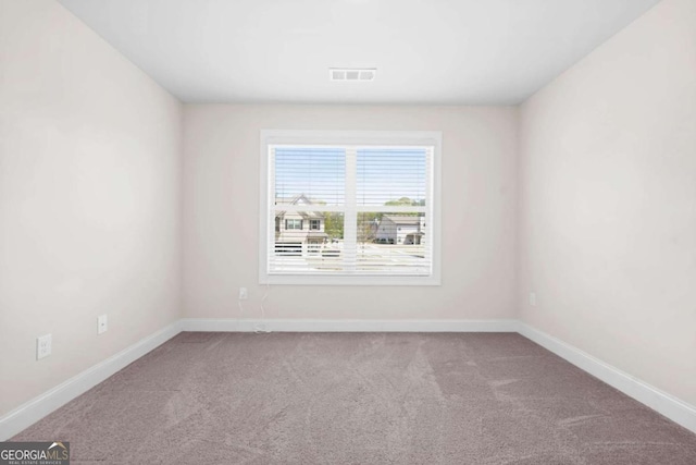 carpeted spare room with visible vents and baseboards