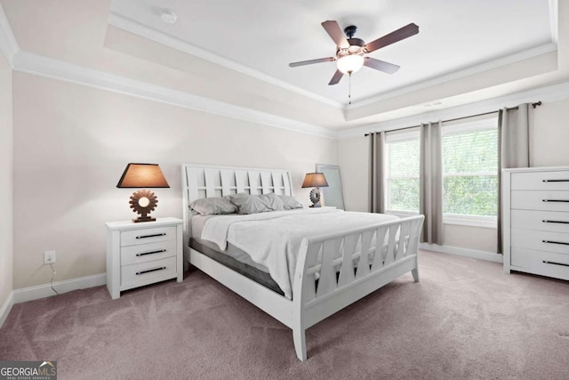 bedroom featuring baseboards, ornamental molding, a ceiling fan, a raised ceiling, and light colored carpet