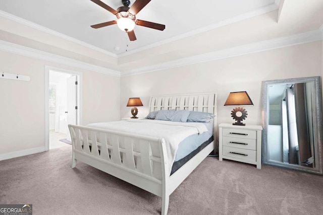 bedroom with ensuite bathroom, baseboards, ornamental molding, a tray ceiling, and light carpet