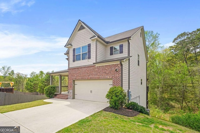 view of front of home with driveway, a front lawn, brick siding, a garage, and fence