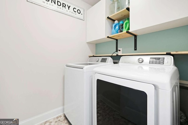 clothes washing area with separate washer and dryer, laundry area, and baseboards