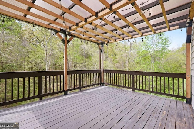 wooden terrace featuring a pergola and a forest view