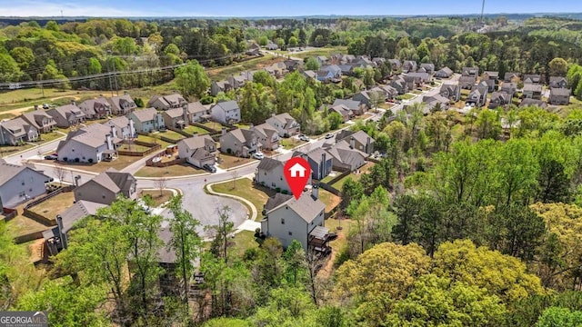 drone / aerial view with a wooded view and a residential view