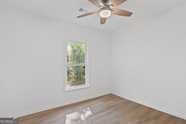 spare room featuring visible vents, baseboards, a ceiling fan, and wood finished floors