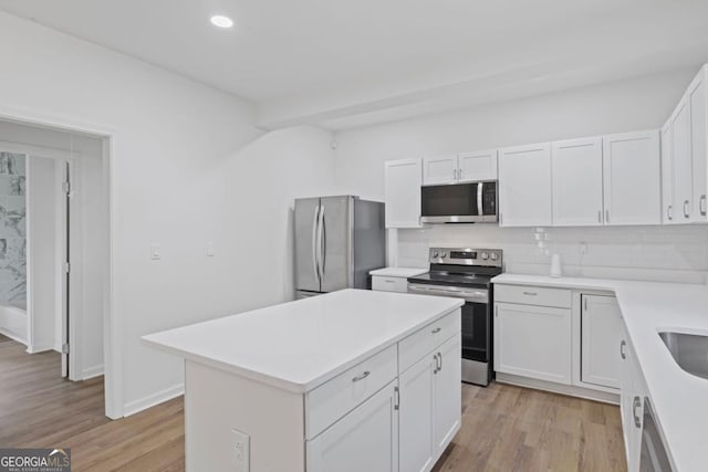 kitchen with white cabinets, light countertops, backsplash, and appliances with stainless steel finishes
