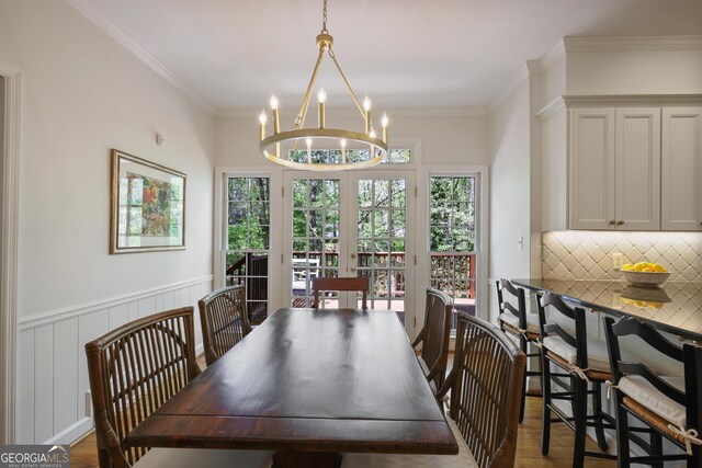 2000 Old Dominion Rd, Atlanta, GA 30350 - dining room featuring crown molding, wood finished floors, a notable chandelier, and a wainscoted wall
