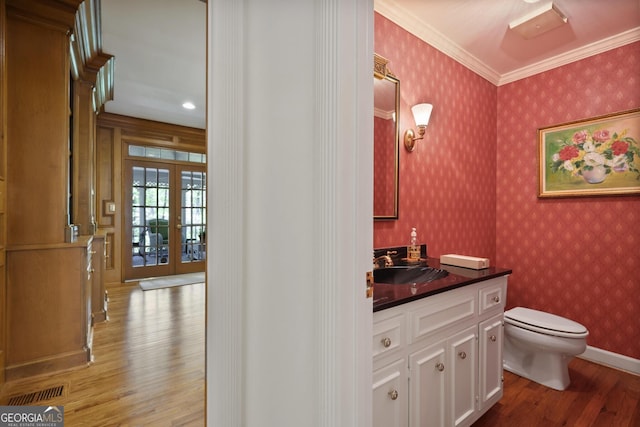 2000 Old Dominion Rd, Atlanta, GA 30350 - half bath with ornamental molding, wallpapered walls, french doors, toilet, and wood finished floors