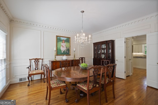 2000 Old Dominion Rd, Atlanta, GA 30350 - dining space with light wood finished floors, a decorative wall, an inviting chandelier, and visible vents