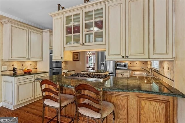 kitchen featuring appliances with stainless steel finishes, a sink, and cream cabinetry
