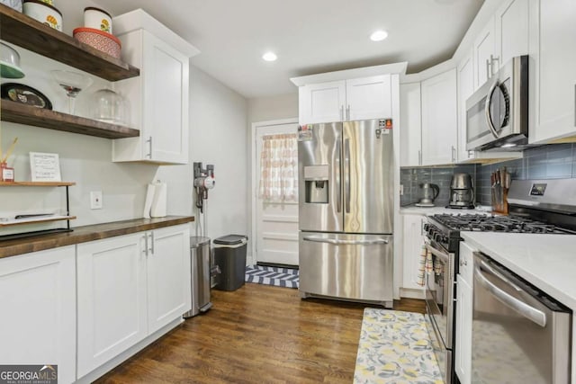 952 Columbia Dr, Decatur, GA 30030 - kitchen featuring open shelves, appliances with stainless steel finishes, white cabinetry, dark wood-style flooring, and tasteful backsplash