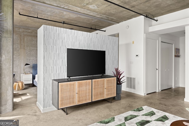 living room with concrete floors, baseboards, and visible vents