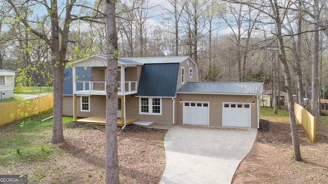 view of front facade featuring concrete driveway, a balcony, an attached garage, metal roof, and a gambrel roof