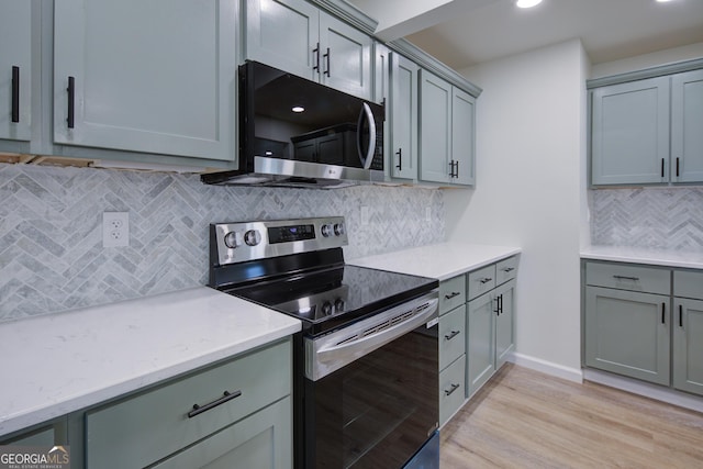 kitchen featuring backsplash, light wood-style floors, gray cabinetry, and stainless steel range with electric cooktop