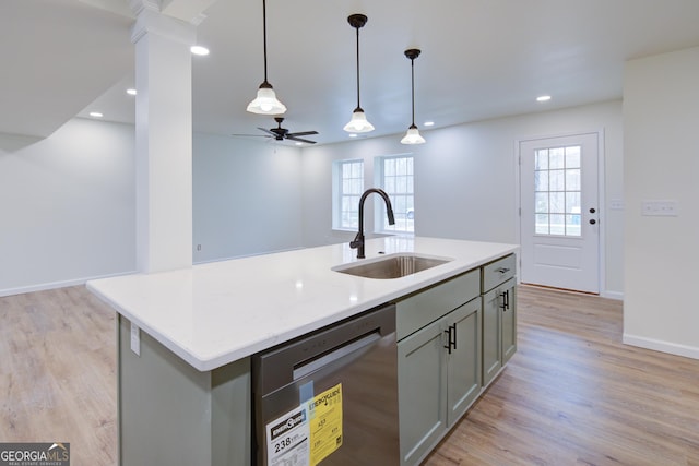 kitchen featuring stainless steel dishwasher, light wood-style flooring, gray cabinets, a sink, and hanging light fixtures