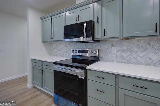 kitchen with gray cabinets, backsplash, light countertops, and stainless steel appliances