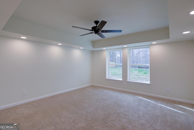 empty room with baseboards, a ceiling fan, a tray ceiling, recessed lighting, and carpet flooring