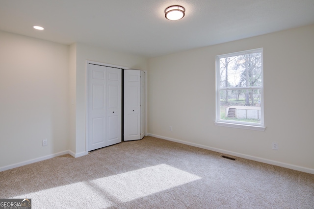unfurnished bedroom featuring baseboards, carpet, visible vents, and recessed lighting