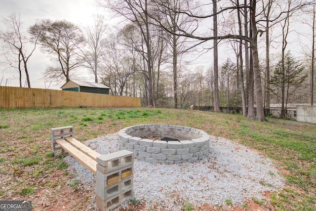 view of yard with an outdoor fire pit and fence