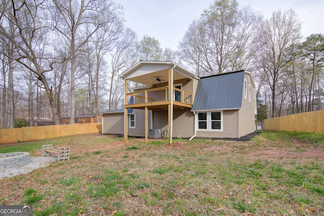 back of house with central AC, a ceiling fan, metal roof, fence, and a balcony