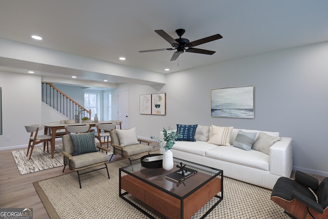 living room with baseboards, recessed lighting, a ceiling fan, stairs, and wood finished floors