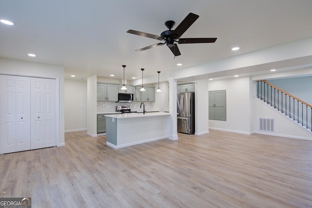 kitchen with light wood-type flooring, visible vents, light countertops, stainless steel appliances, and open floor plan