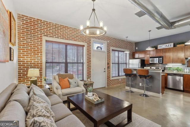 791 Wylie St SE Unit 1111, Atlanta, GA 30316 - living area with brick wall, concrete flooring, and an inviting chandelier
