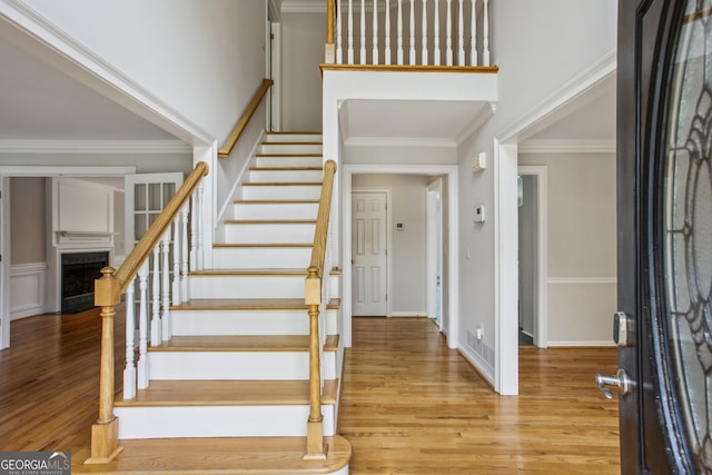 4284 Windy Gap Ct NW, Kennesaw, GA 30144 - foyer featuring a fireplace, stairway, light wood-style floors, and ornamental molding