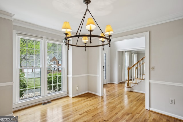 4284 Windy Gap Ct NW, Kennesaw, GA 30144 - unfurnished dining area featuring baseboards, an inviting chandelier, ornamental molding, stairway, and light wood-style flooring