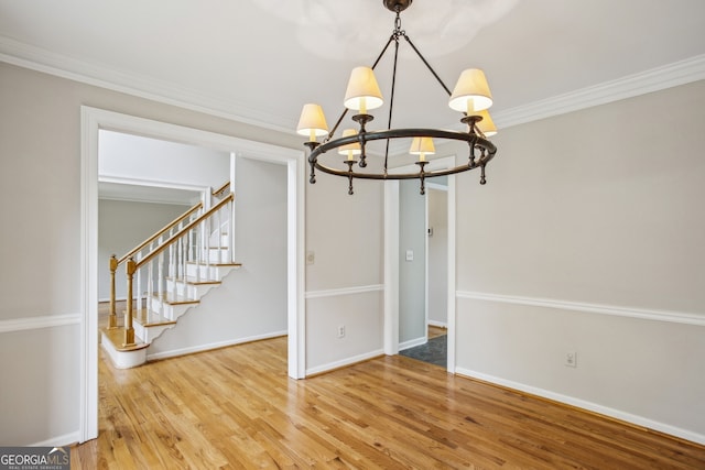 4284 Windy Gap Ct NW, Kennesaw, GA 30144 - unfurnished dining area featuring ornamental molding, wood finished floors, stairs, a notable chandelier, and baseboards