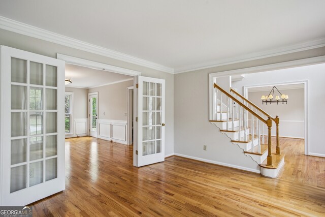 4284 Windy Gap Ct NW, Kennesaw, GA 30144 - empty room with a chandelier, stairway, french doors, crown molding, and wood finished floors